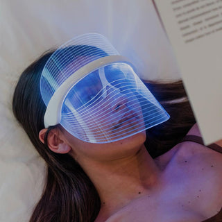 Woman relaxing with Luma Aesthetic Shield LED therapy mask on her face.
